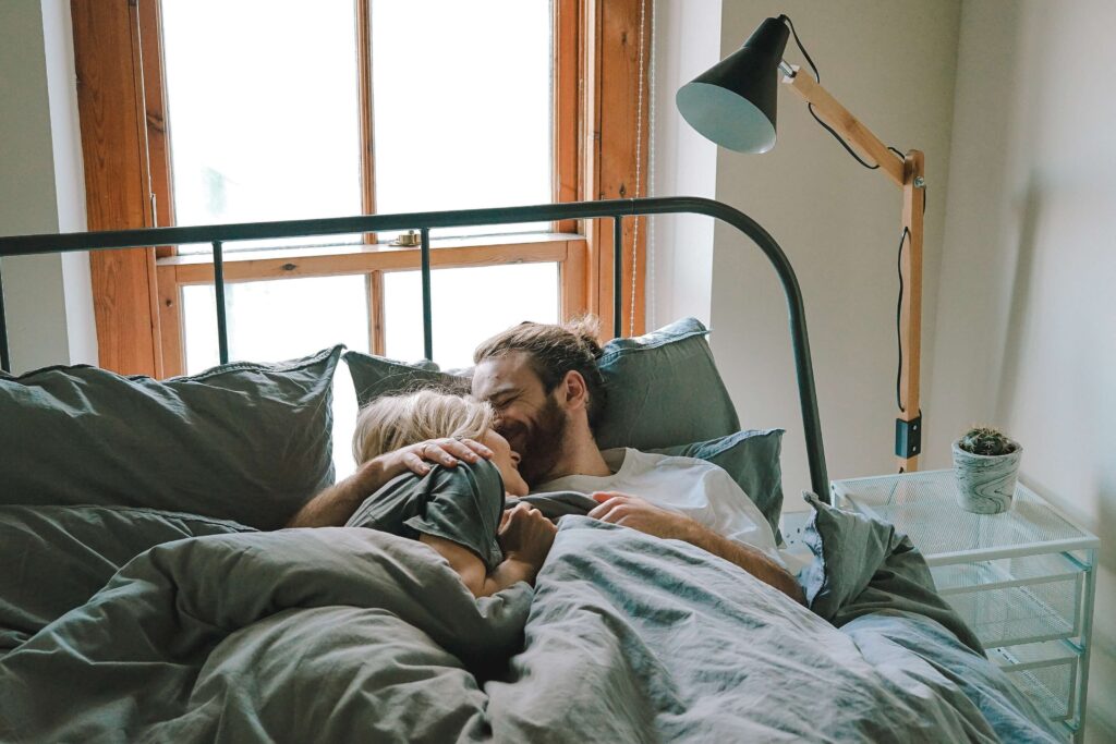 image of couple laughing in bed