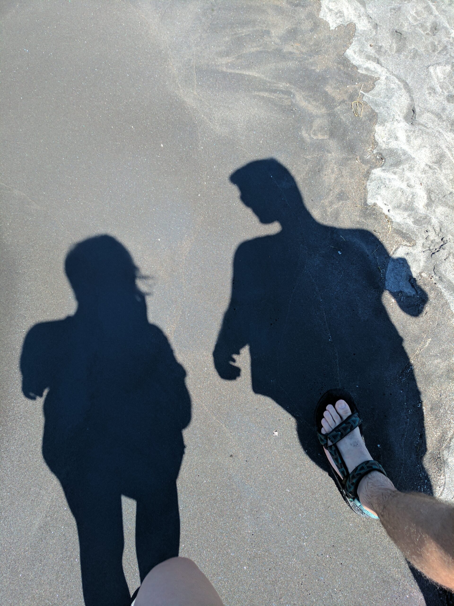 shadows of a couple walking on the beach